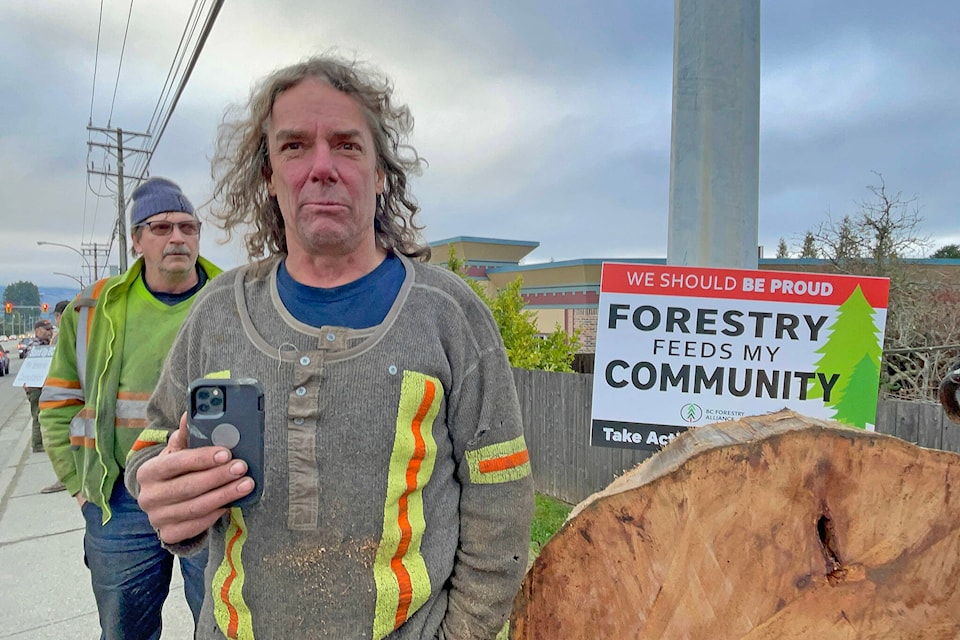 Brad Cyr is a third-generation logger from Port Hardy who began working a union job as a grapple yarder in Port Alberni in December. He brought his concerns and a freshly cut slice from a stump to the ‘Stand Up for Forestry’ rally on Johnston Road Dec. 9, 2021. (SUSAN QUINN/ Alberni Valley News)