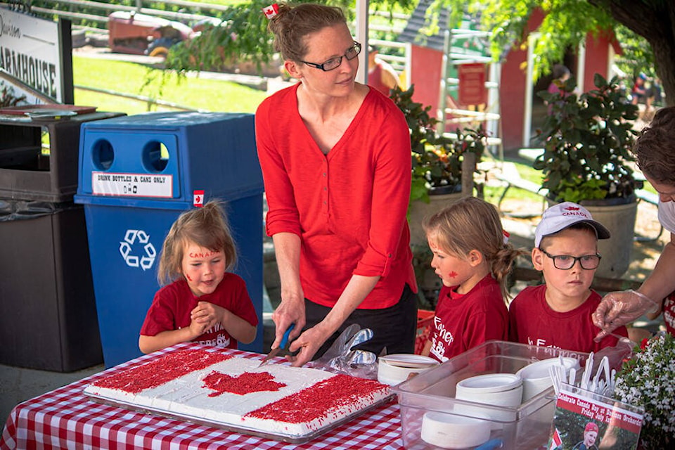 Rachel Davison serves up cake while her daughter Jane (fifth generation) eagerly eyes a slice at Davison Orchard during Canada Day celebrations Friday, July 1. (Contributed)