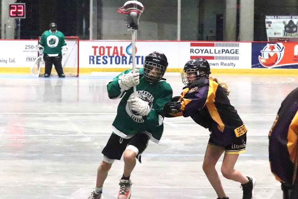 Alexander Dolmat of the Burnaby Lakers (with ball) fends off a check from Grace Chartier of the North Okanagan Shepherd’s Hardware Legends during the gold-medal game of the B.C. Minor Lacrosse U15 C Division Championships Sunday, July 17, at Kal Tire Place in Vernon. The Lakers defeated the Legends 9-6. (Roger Knox - Morning Star)