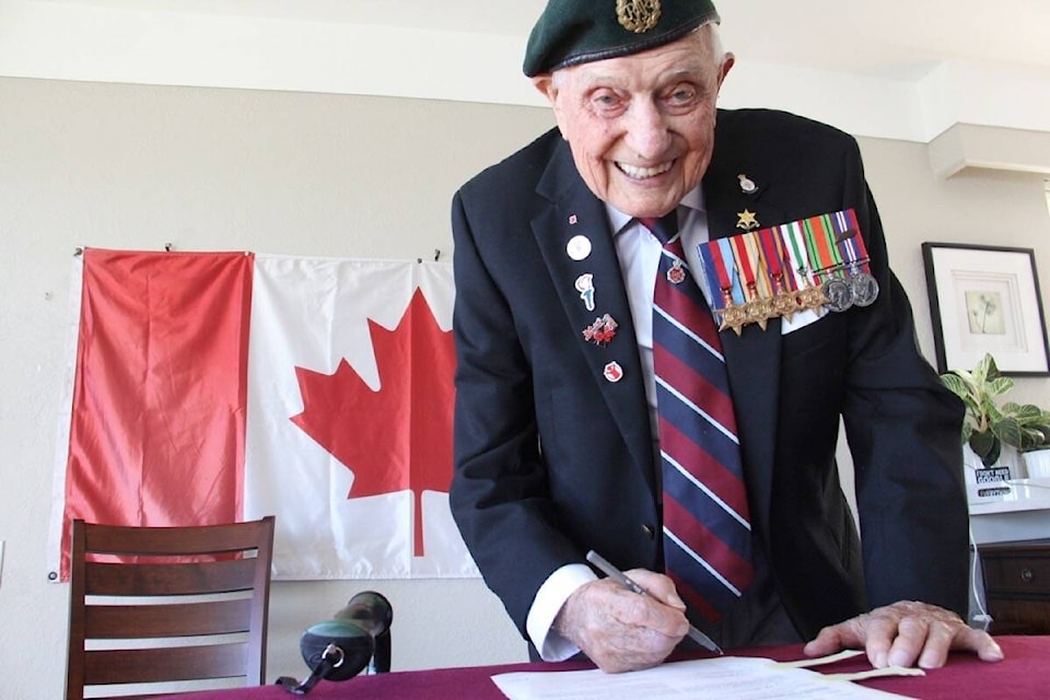 John Hillman, then 103, signs the papers that make British veteran officially a Canadian citizen in 2022. (Christine van Reeuwyk/Oak Bay News)