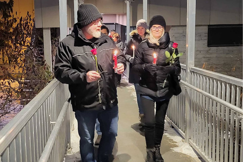 Vernon councillor Kelly Fehr, left, and Kelli Sullivan from the Archway Society for Domestic Peace lead 14 people in a candlelight vigil and rose ceremony Tuesday, Dec. 6, at the Vernon campus of Okanagan College. The vigil was held on National Day of Remembrance and Action on Violence Against Women to commemorate 14 women killed at a Montreal school on Dec. 6, 1989, as well as the current Murdered and Missing Indigenous Women and Girls (MMIWG). (Roger Knox - Morning Star)