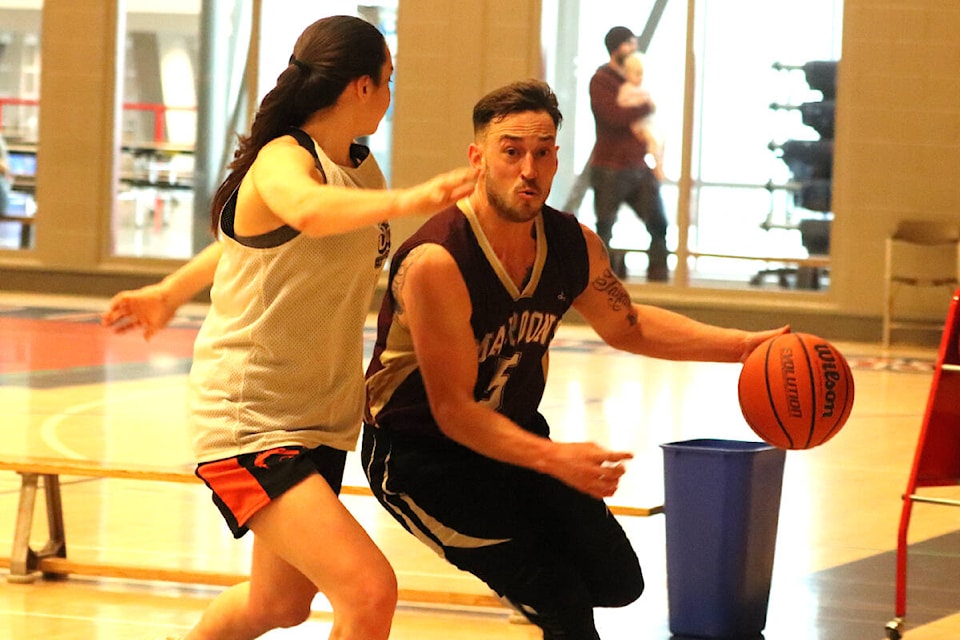 Megan Rouault (left) tries to prevent Jesse Brown from getting to the baseline during the return of the Greater Vernon Alumni Basketball Tournament, held Dec. 26 and 27 at Vernon Secondary School. (Roger Knox - Morning Star)