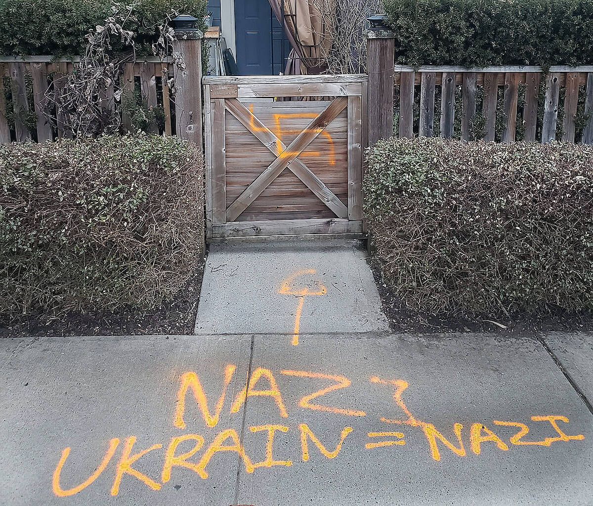 Someone spray painted a swastika and anti-Ukraine graffiti (left) at a Langley townhouse on Thursday, March 9. Police are investigating. (Courtesy Kiersten Bisgaard)