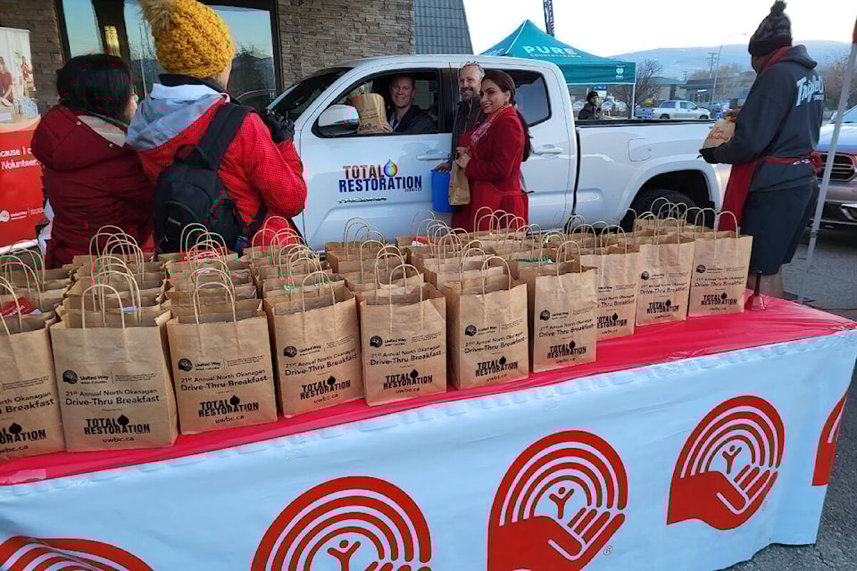 Vernon-Monashee MLA Harwinder Sandhu (centre) was among the dignitaries helping out at the 21st annual United Way B.C. North Okanagan Drive-Thru Breakfast Wednesday, March 22, at the Prestige Vernon Lodge and Conference Centre. The event was presented by Total Restoration, which was also among the first customers. (Roger Knox - Morning Star)