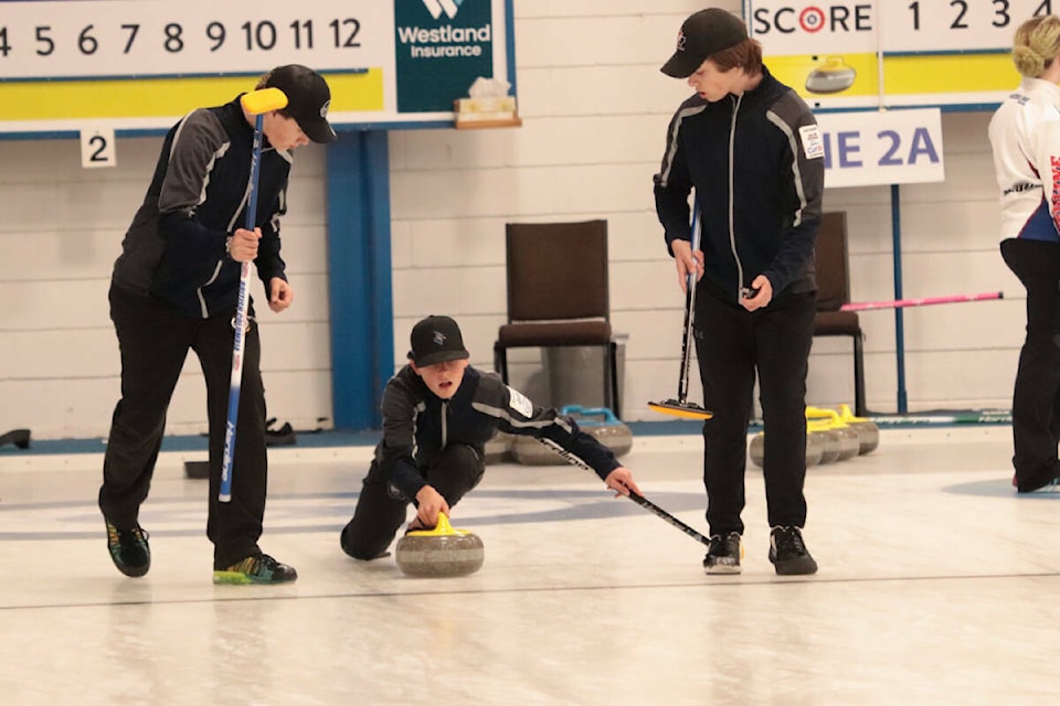 Elias Rands delivers a rock to sweepers Nolan Beck (left) and Alex Watkins, while skip Kaiden Beck waits in the house. The Salmon Arm quartet won the gold medal at the men’s curling competition at the Greater Vernon 2022 B.C. Winter Games from the Vernon Curling Club (Roger Knox- Black Press).