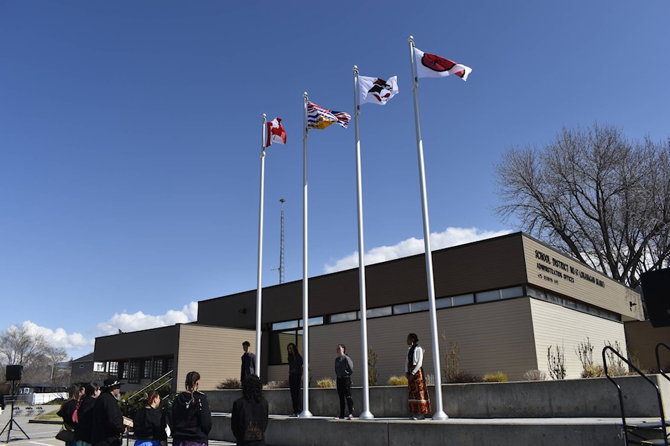 Local high school students help raise the Penticton Indian Band, Okanagan Nation Alliance, Canadian and B.C. provincial flags outside School District No. 67’s main building. (Logan Lockhart- Western News)