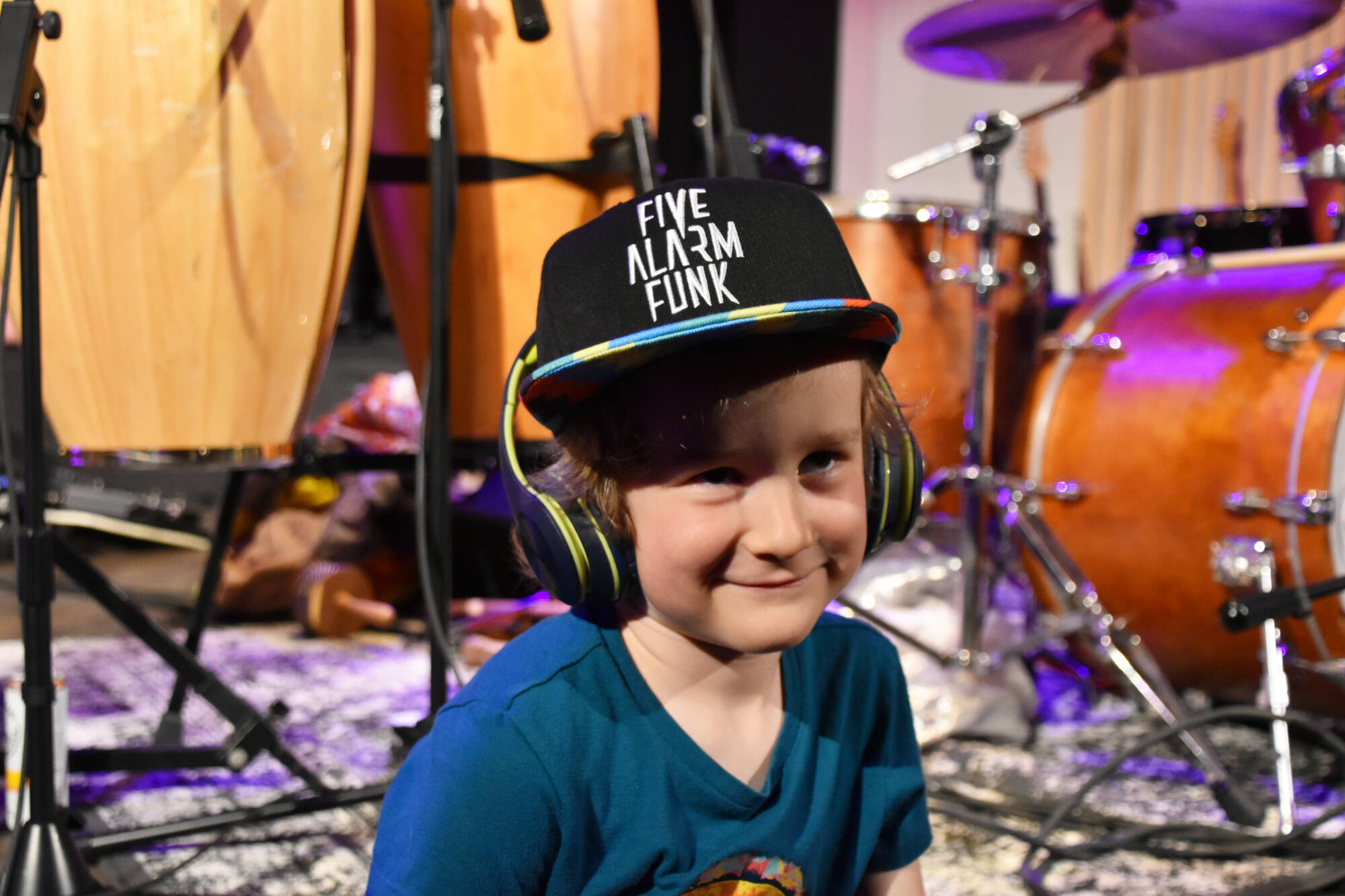 Five-year-old Fletcher Price, a big fan of drummer Tayo Branston, sits on the stage during a break at Five Alarm Funks sold-out concert/dance party at Song Sparrow Hall in Salmon Arm on April 16. (Martha Wickett/Salmon Arm Observer)