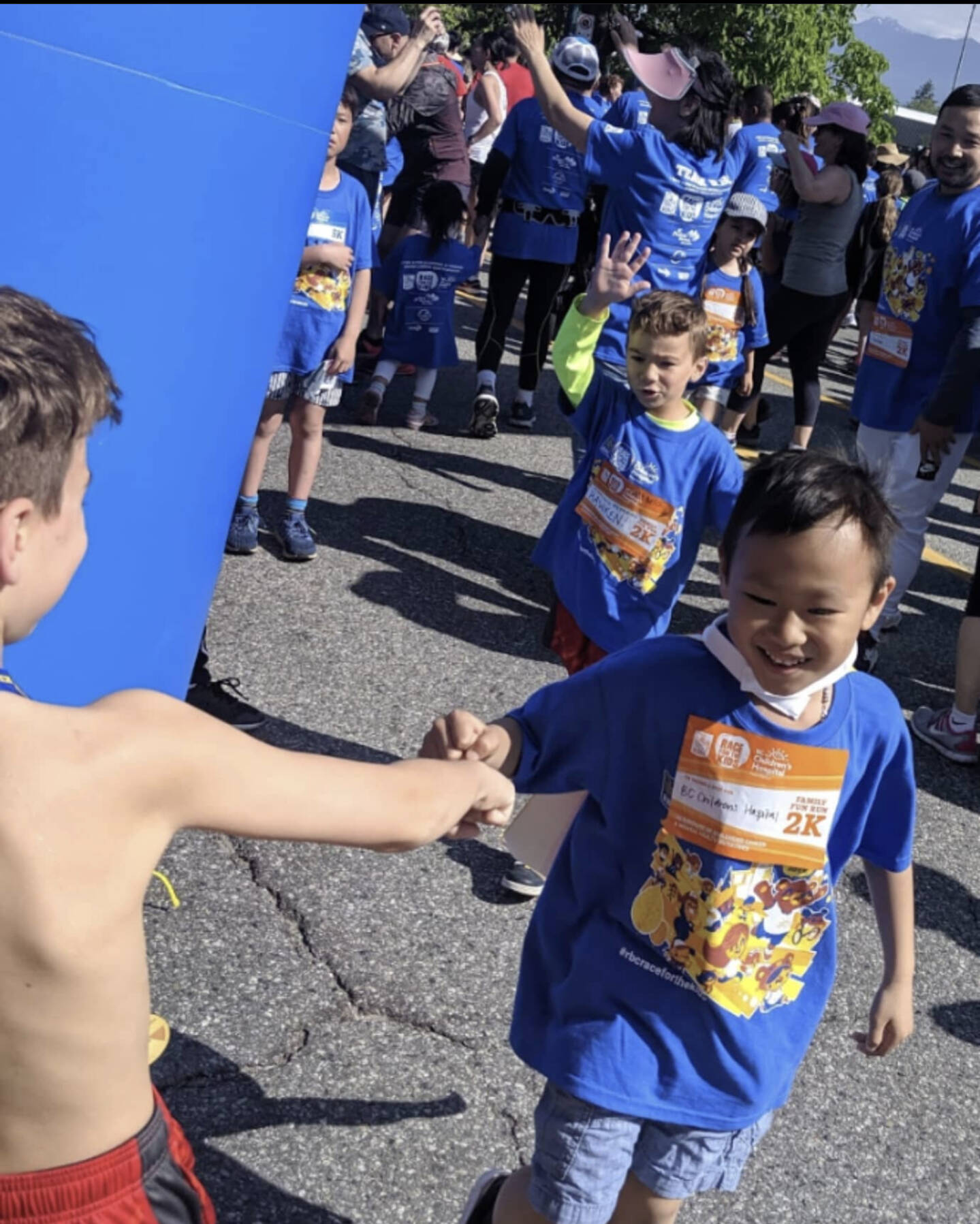 The Cannon family is taking part in the RBC Race for the Kids again this June after their eldest son's battle with cancer. Pictured is Nick Cannon, left, cheering on a family friend, who was previously diagnosed with cancer, in the 2019 race. Nick ended up being diagnosed with cancer in March 2021 and is cancer free as of September 2022. (Submitted by Kelly Cannon)