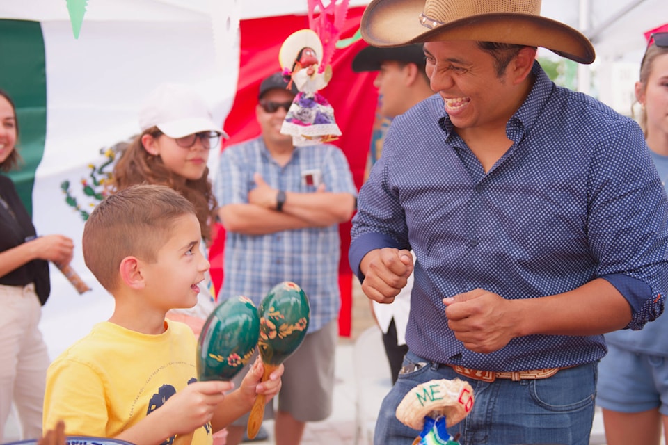 Fernando Arechederra H. receives instruction on how to use maracas from Ivan Gracia at the table celebrating Mexico in the Gathering Together Festival held in downtown Salmon Arm on Multiculturalism Day, Tuesday, June 27, 2023. (Lachlan Labere-Salmon Arm Observer)