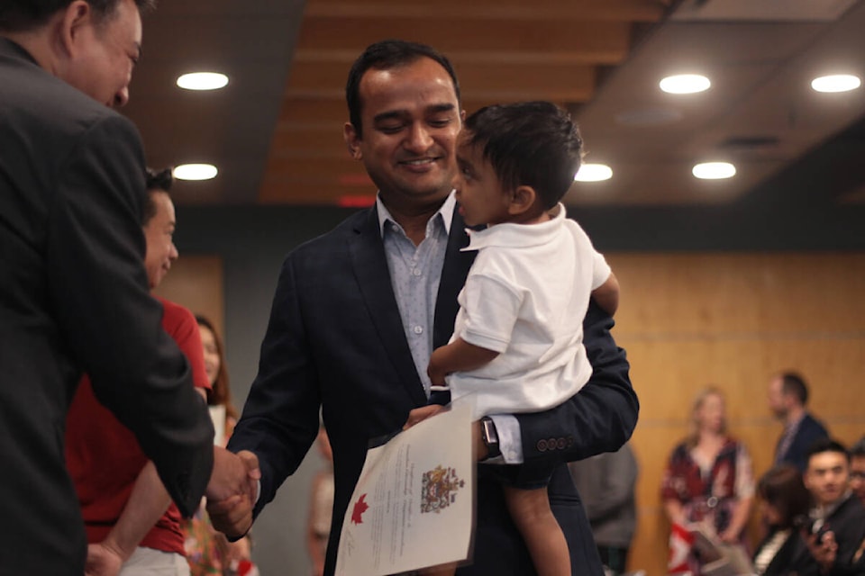 Nitin Goyal, and his son 18-month-old Ansh, shake hands with a politician after Goyal received his citizenship Saturday (July 1, 2023) during a ceremony at the ceremony at the Immigration, Refugees and Citizenship Canada’s Vancouver location for Canada Day. (Lauren Collins)