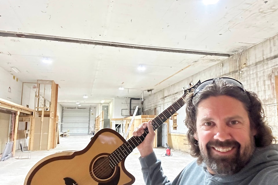 Mike Miltimore, owner/founder of Riversong Guitars, holds up a guitar in his new manufacturing facility in Sicamous, set to open in late fall. (Mike Miltimore photo)