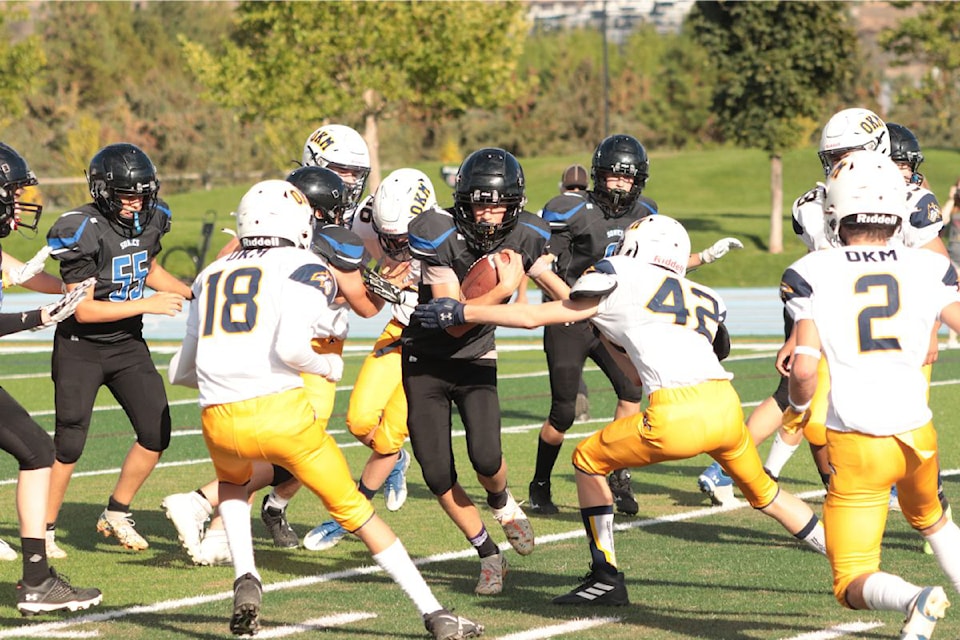 Seaton/Kalamalka Sonics quarterback Ty Johannson (centre) tries to find some room between Okanagan Mission Huskies defenders during Okanagan AA Junior Varsity Football League action Thursday, Sept. 19, at Greater Vernon Athletic Park.