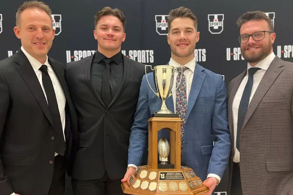 's Nate Beauchemin (second from right) holds the President's Trophy for U-Sports Football Defensive Player of the Year. Beauchemin and Calgary Dinos  defensive teammate Liam Reid of Vernon (second from left) were named U-Sports First Team All-Canadians. Celebrating the honours are Calgary head coach Ryan Sheahan (left) and defensive co-ordinator Ben D'Andrea (right).