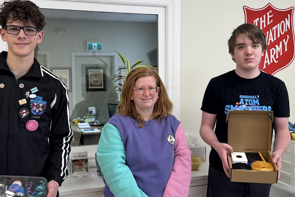 Team captains of the Esquimalt Atom Smashers Colin Morris, left, and Esquimalt Proton Pulverizers Bennett Fulcher drop off fidgets and 3D printed toys for teenagers to Sarah O'Connor from Salvation Army. 