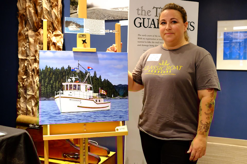 Sooke artist Christina Morrison proudly poses next to a painting of hers showcasing the Messenger III.
