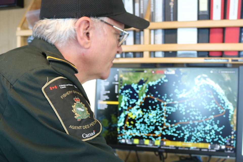 Officer in charge, Wayne Johnston, searches for potential illegal fishing using the dark vessel detection machine.
