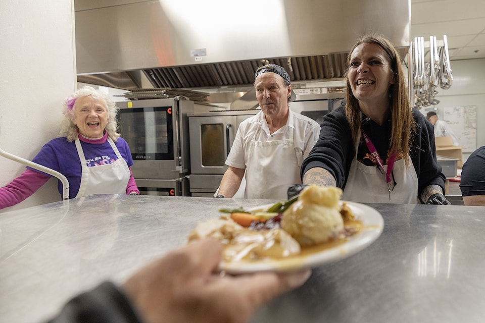 Staff and volunteers including Victoria News publisher Randi Page (right) help make and serve Dodd’s Thanksgiving Dinner at the Our Place Society’s dining hall where Dodd’s Furniture and Mattress has sponsored a meal twice a year for 26 years. 