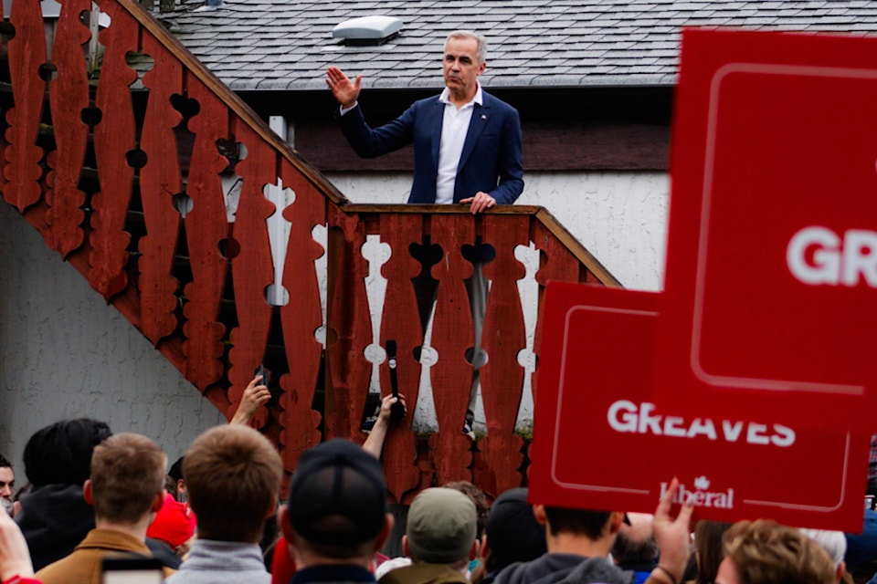 Liberal Leader Mark Carney waves to the crowd after his address during his first visit to B.C. at the Victoria Edelweiss Club in James Bay.