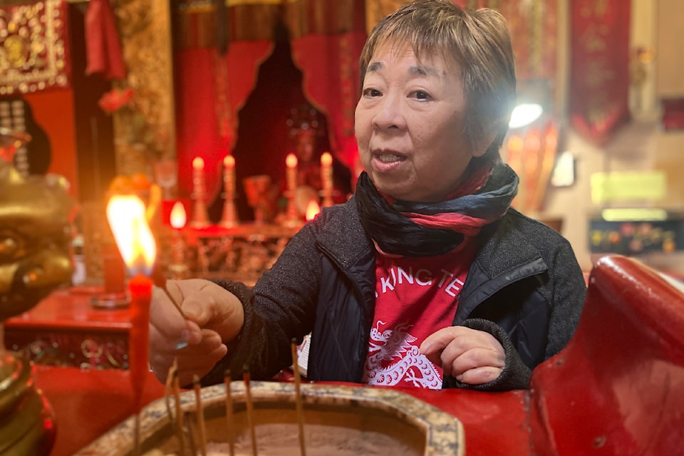 Gayle Nye lights incense in the Tam Kung Temple in Victoria.