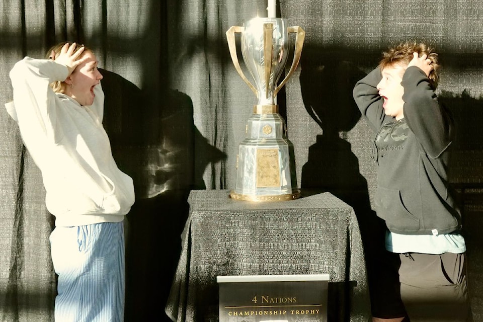 Kenzie Rigel and Anton Matsigura marvel at the 4 Nations Face-Off trophy on display at the NHL Street season finale Tuesday night in Victoria.