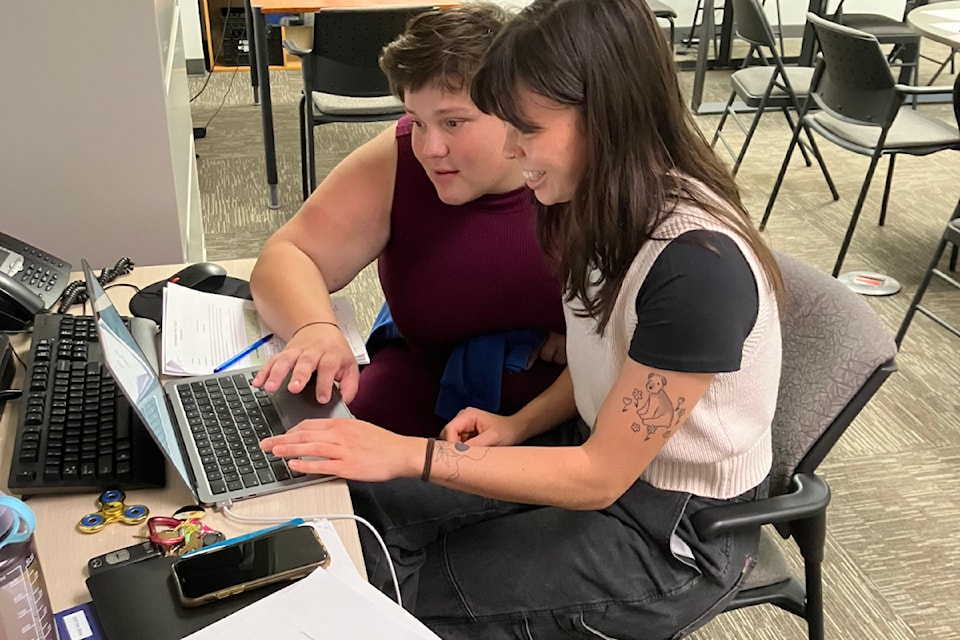Staff and a member navigate excel sheets at the Connections Place Clubhouse in Victoria.