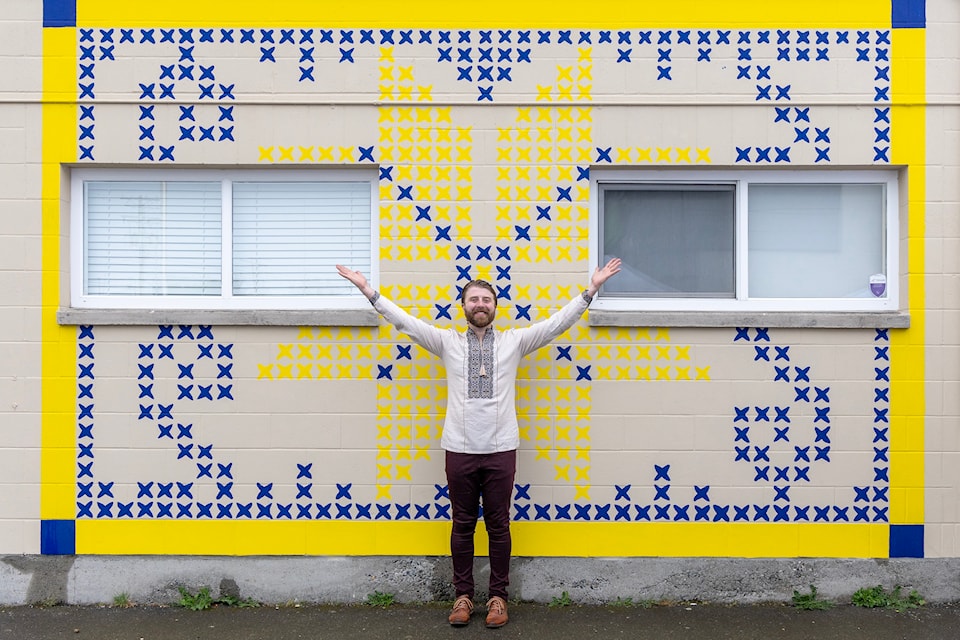 Dillon Lew'chuk celebrates his mural Resilience, Pride and Protection, a public art project with the Victoria Arts Council as part of the STEPS Public Art Residency, and his first public art project.