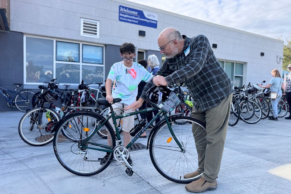 A Ride it Forward volunteer helps a student inspect his bicycle.