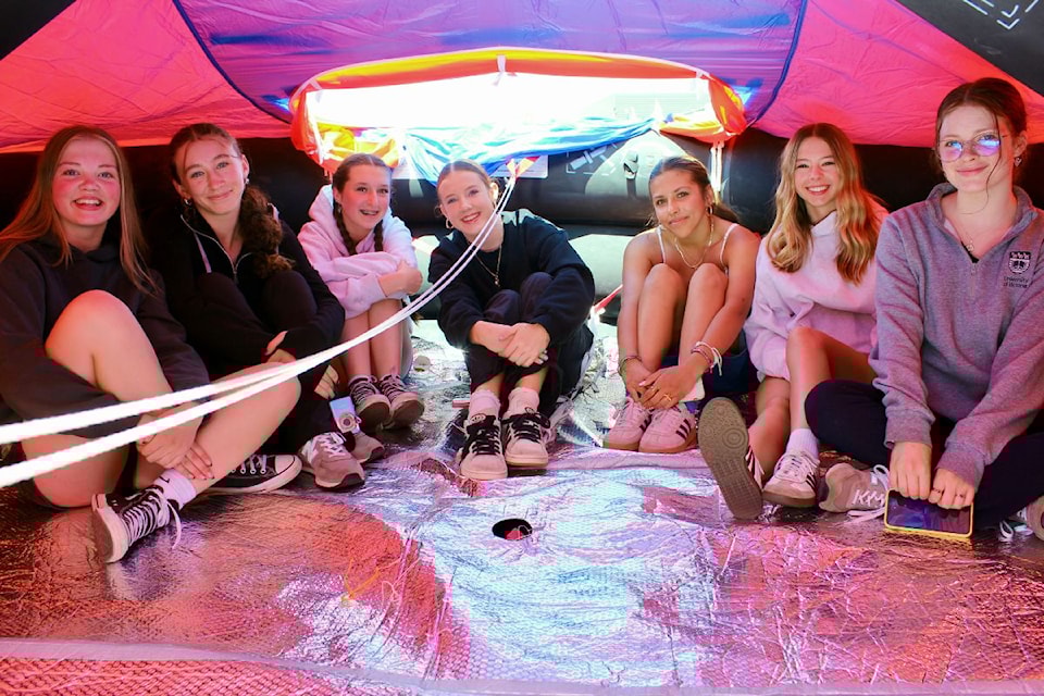 A group of students checks out the inside of a 20-person safety raft on Thursday.