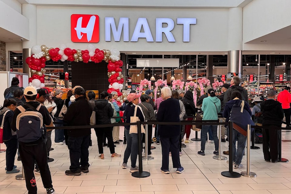 Dozens gather outside the Asian supermarket on opening day, May 22.