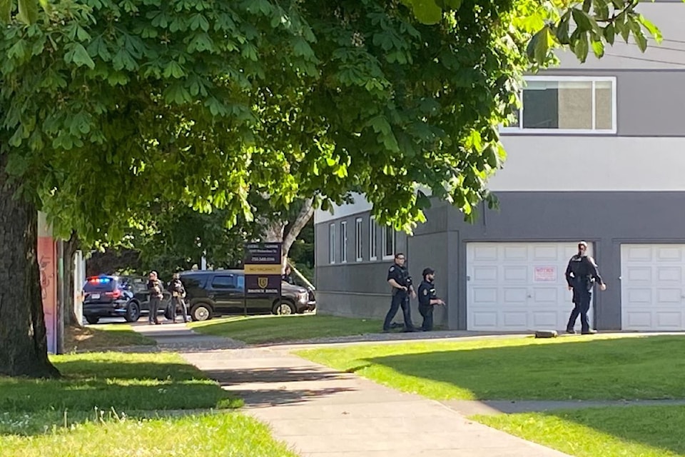 On May 22, around 3:50 p.m., several police officers can be seen outside of an apartment building.