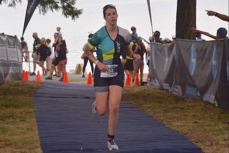 Beata Friesen crosses the finish line at the 2023 Elk Lake Triathlon. (Brendan Mayer/News Staff) 