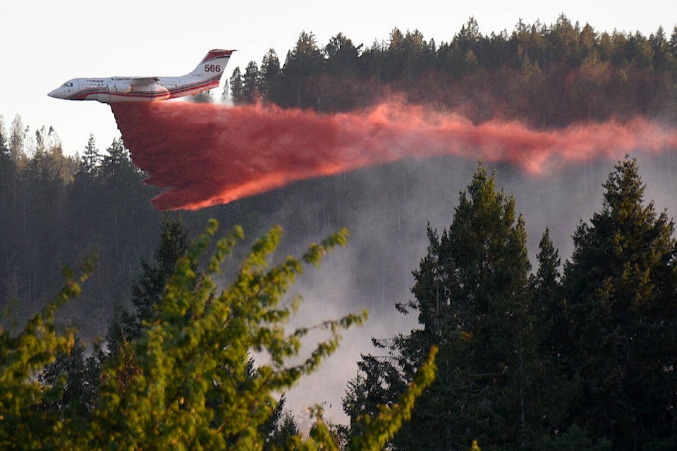 A land-based airtanker from Conair Aerial Firefighting drops retardant on a wildfire on Arbutus Mountain behind Shoemaker Bay, Thursday, Aug. 3, 2023. (SUSAN QUINN/ Alberni Valley News) 