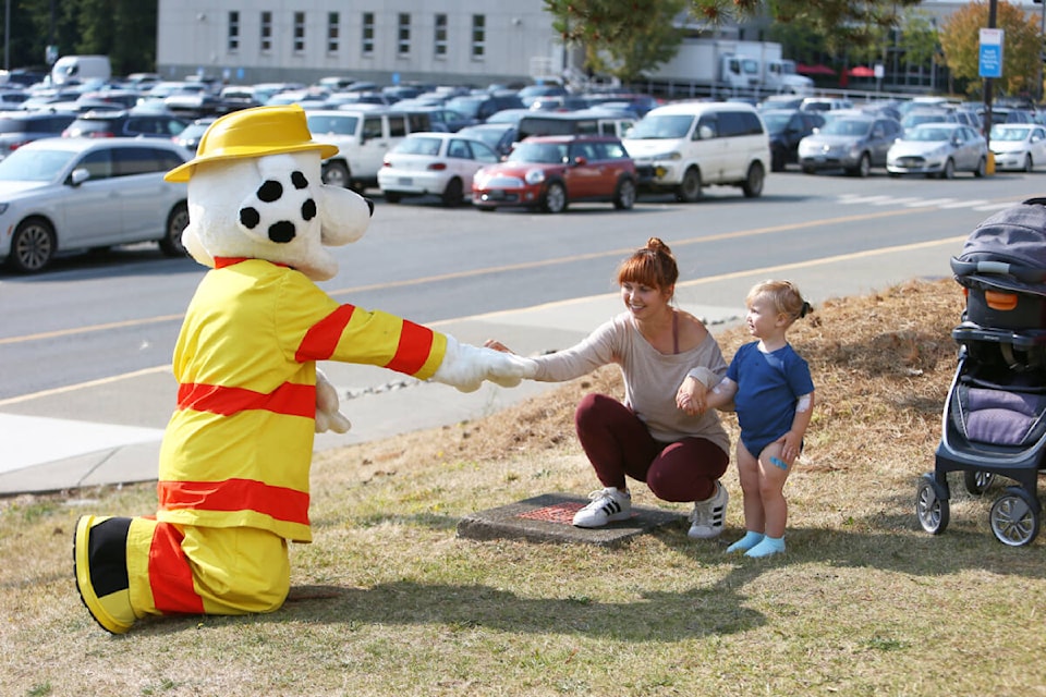 Sparky the Fire Dog befriends Myesha and Clara Lyndan Thursday, Aug. 24 after the Professional Firefighters of Greater Victoria Community Foundation made a donation of $25,000 to the Victoria Hospital Foundation to purchase critical equipment for the Victoria General Hospital. (Justin Samanski-Langille/News Staff) 