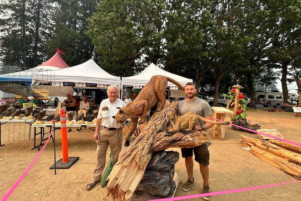 Ryan Villiers (right) standing with Heinz Schiller, long-time business owner and purchaser of his entry for this year’s World Class Chainsaw Carving competition in Hope. Villiers won the Pro-Carver class with his carving of a mountain lion and cub. (Hope Communities in Bloom) 