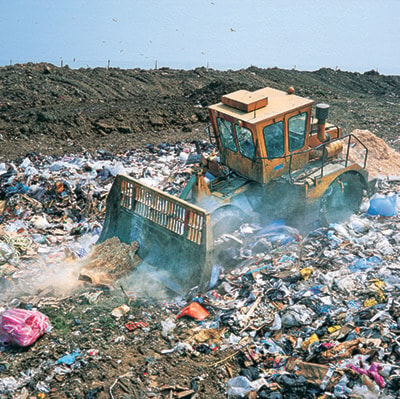 Bulldozer working on landfill site, UK