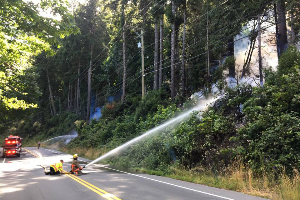 Fire crews from Metchosin, Langford, Sooke, East Sooke, and Otter Point fire departments all joined forces to battle a brush fire along Sooke Road Wednesday afternoon. (Photo by Stephanie Dunlop/Facebook)