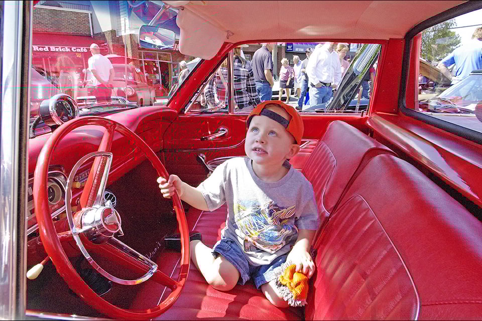 Two-year-old Jaxson Howells of Victoria does his best to keep the interior of a classic car clean during the 2017 Coast Capital Auto Extravaganza in Sidney, hosted by the Torque Maasters Car Club. (Steven Heywood/News staff)