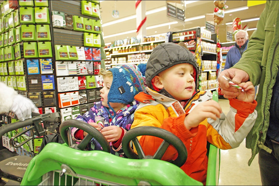 Hanna and Levi Shannon enjoy some candy canes from Santa and dad Anthony at Save-On-Foods. (Steven Heywood/News Staff)