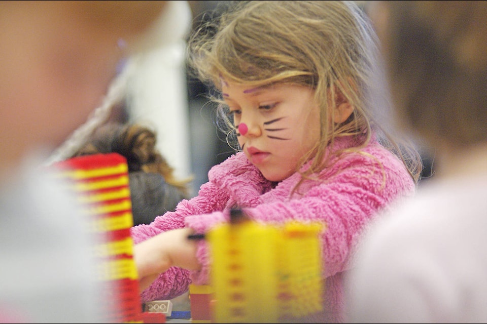 Acacia Mackie, 4, of Brentwood Bay, has her face painted like a cat and works diligently on her own LEGO model Monday, Feb. 12 at the Mary Winspear Centre during Sidney’s Family Day festivities. (Steven Heywood/News Staff)