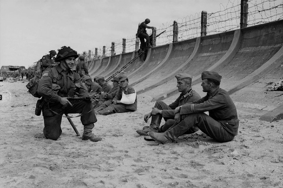 German Prisoners watched by a Canadian soldier on Juno Beach, after D-Day, on June 6, 1944. (THE CANADIAN PRESS/National Archives of Canada, Frank L. Dubervill)
