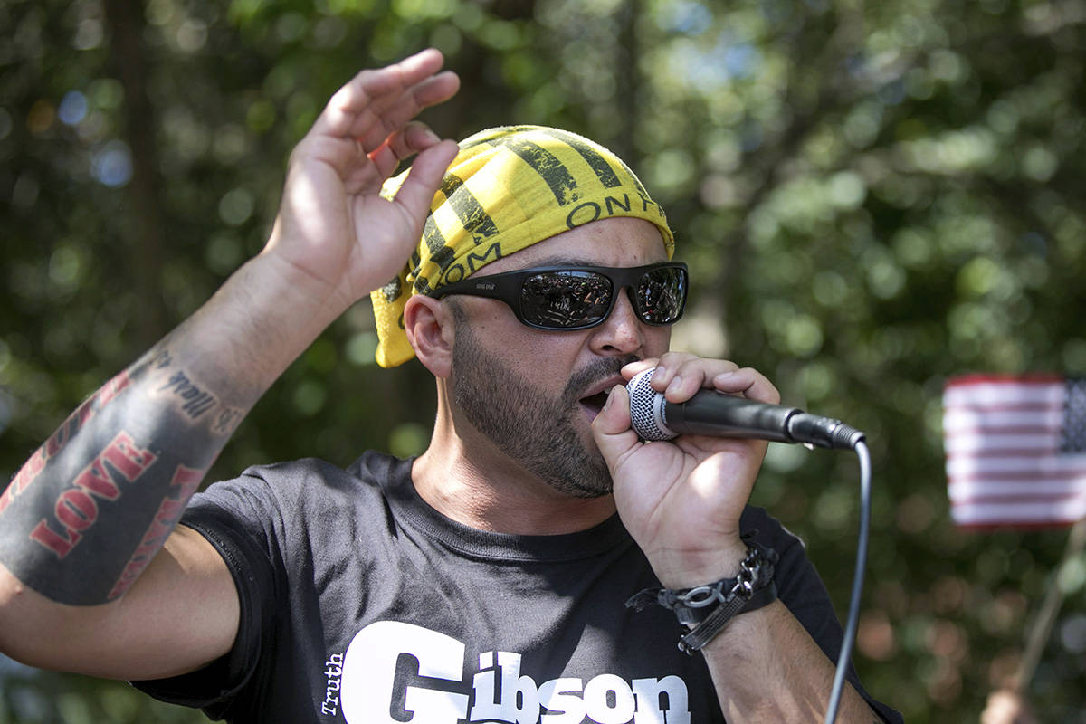 FILE - In this Aug. 4, 2018 file photo, Patriot Prayer founder and rally organizer Joey Gibson speaks to his followers at a rally in Portland, Ore. On Friday, Aug. 16, 2019 authorities announced they’ve arrested Gibson, the leader of the right-wing group, on the eve of a far-right rally that’s expected to draw people from around the U.S. to Portland on Saturday, Aug. 17, prompting Gibson to urge his followers to “show up one hundred-fold” in response. (AP Photo/John Rudoff, File)