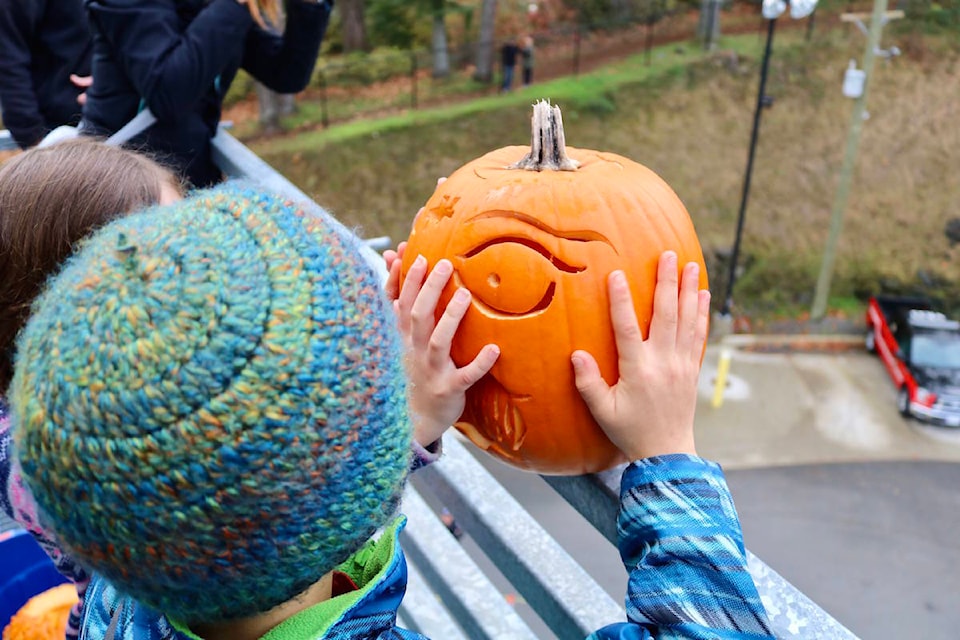 View Royal residents push their aging Halloween pumpkins off of the fourth level of the View Royal Fire Hall’s training tower for the 3rd Annual Pumpkin Smash. (Aaron Guillen/News Staff)