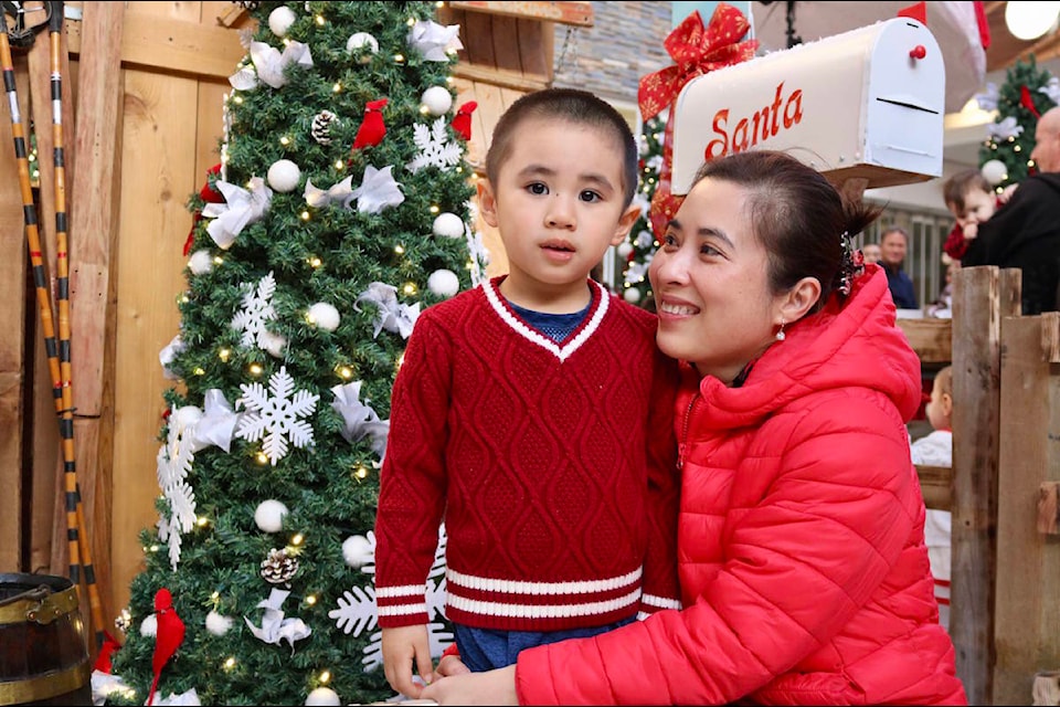 Vy Duong (right), brought her son, Kevin, to the Santa parade at Westshore Town Centre for the first time on Nov. 25. (Aaron Guillen/News Staff)