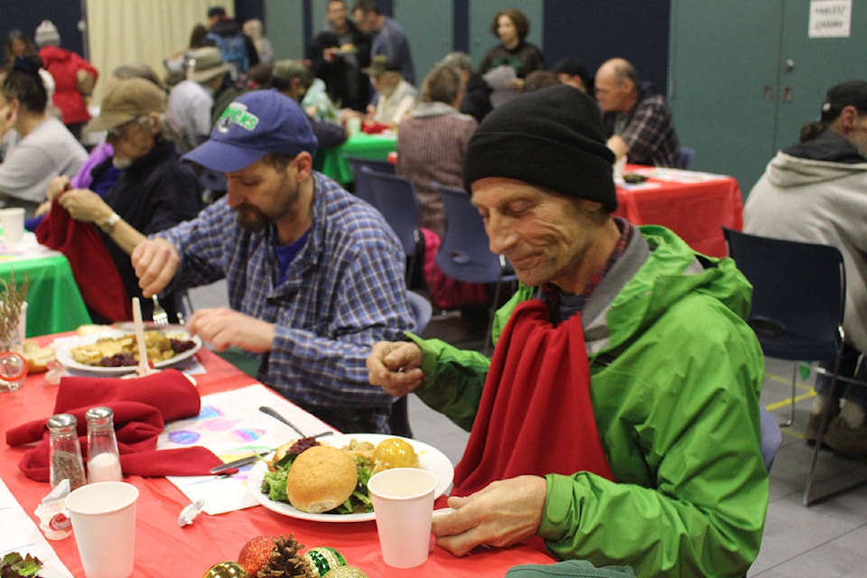 Ricky Sauer and John Henson enjoy a Christmas dinner at Cool Aid’s downtown Victoria community centre. (Shalu Mehta/News Staff)