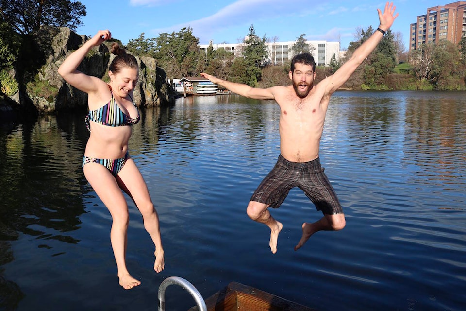 Regular polar bear swimmers Anya Reid (left) and Hayes Zirnhelt jump back into freezing waters after taking their first dip moments before. (Aaron Guillen/News Staff)