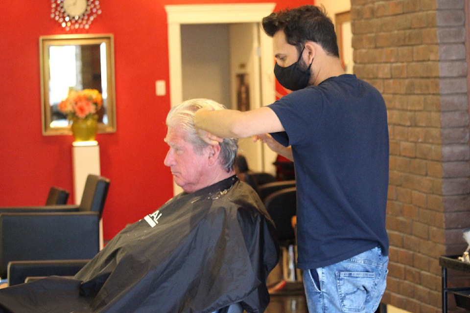 Nomi Atif, owner of Nomi Salon on Blanshard Street cuts Michael O’Connor’s hair on May 19. O’Connor said he was waiting to receive a haircut for a long time. (Shalu Mehta/News Staff)