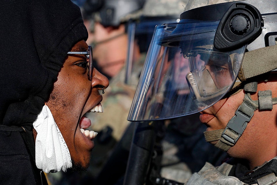 Protesters and National Guardsmen face off on East Lake Street, Friday, May 29, 2020, in St. Paul, Minn. Protests continued following the death of George Floyd, who died after being restrained by Minneapolis police officers on Memorial Day. (AP Photo/John Minchillo)
