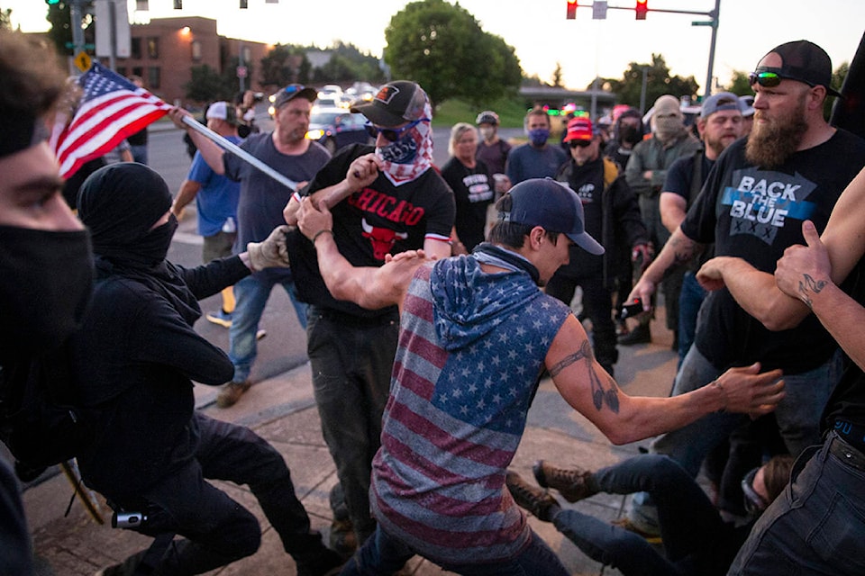 Protesters and counter protesters clash in front of the Federal Courthouse in Eugene, Ore. Saturday July 26, 2020. Authorities declared a riot early Sunday in Portland, Oregon, where protesters breached a fence surrounding the city’s federal courthouse where U.S. agents have been stationed. (Chris Pietsch/The Register-Guard via AP)