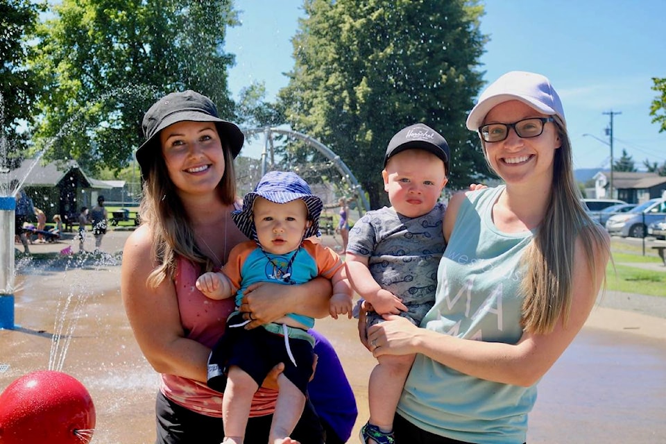 Six-month-old Finn Boyle (middle left) and 18-month-old Lucas Anderson enjoy the sights and sounds of the splash park with moms Natasha Boyle and Ashley Anderson at Langford’s Centennial Park. (Aaron Guillen/News Staff)