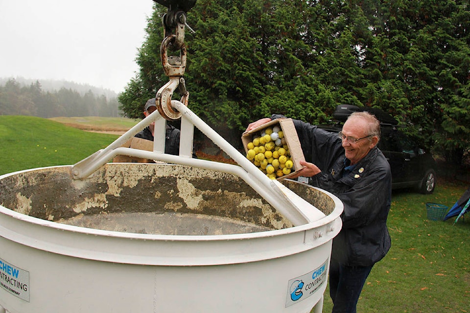 A West Shore Rotary Club member unloads a box of golf balls into a crane bucket for their Golf Ball Drop fundraiser. (Jane Skrypnek/News Staff)